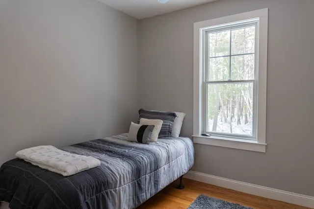 a bedroom with a bed and wooden floor