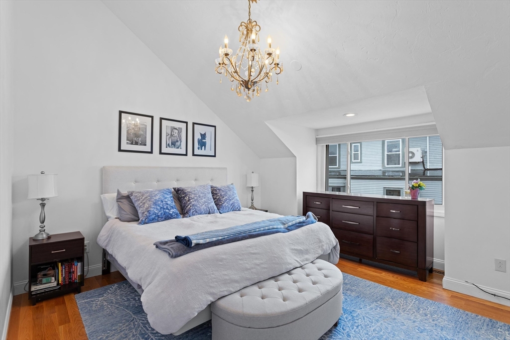 2 Chase Lane, Unit 2 Lynn, MA 01902 - Photo 28 of 42 a bedroom with a large bed and a chandelier