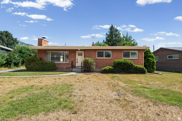 542 East 3400th Street North Provo, UT 84604 - Photo 3 of 39 Red brick exterior with a prominent chimney feature, an inviting front entry, and mature landscaping