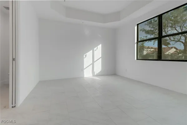 an empty room with windows and chandelier