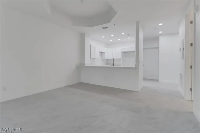 an empty room with a kitchen and a sink