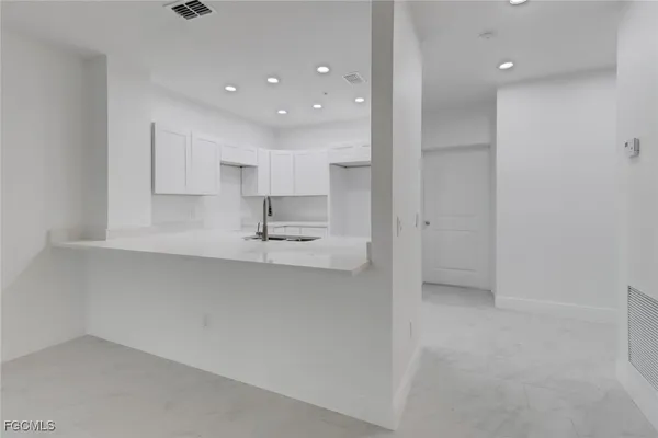 a kitchen with kitchen island a sink stainless steel appliances and cabinets