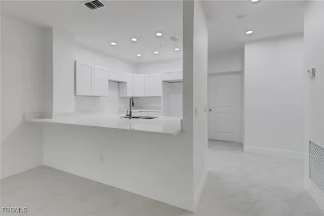 a kitchen with kitchen island a sink stainless steel appliances and cabinets