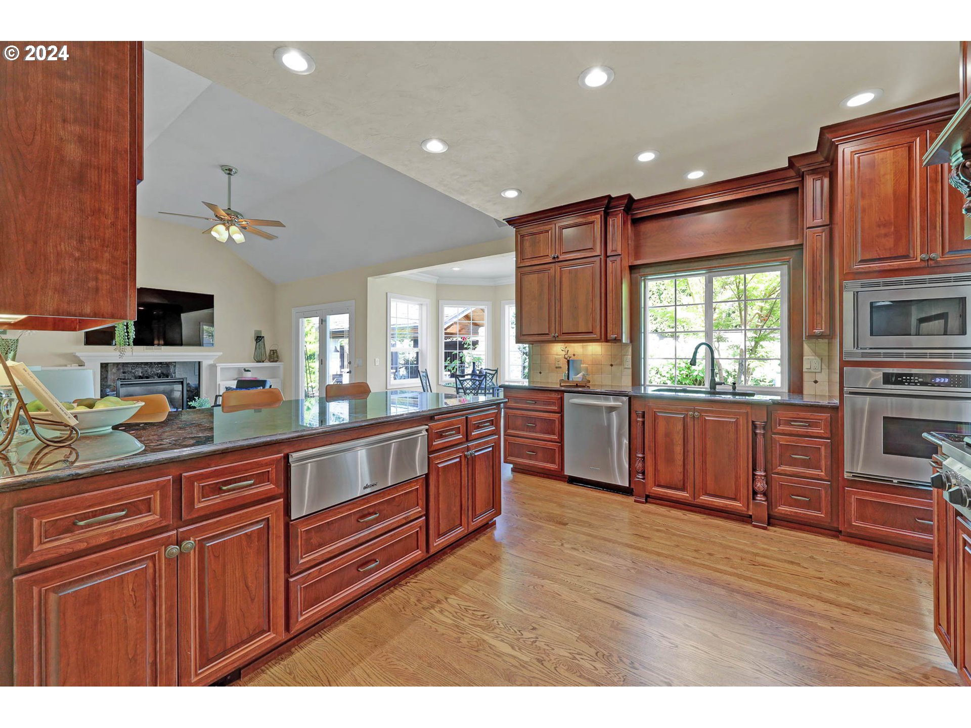 3469 River Pointe Drive Eugene, OR 97408 - Photo 10 of 48 a open kitchen with stainless steel appliances granite countertop a stove a sink dishwasher and wooden cabinets with wooden floor