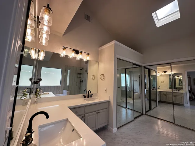 a bathroom with a double vanity sink mirror and shower