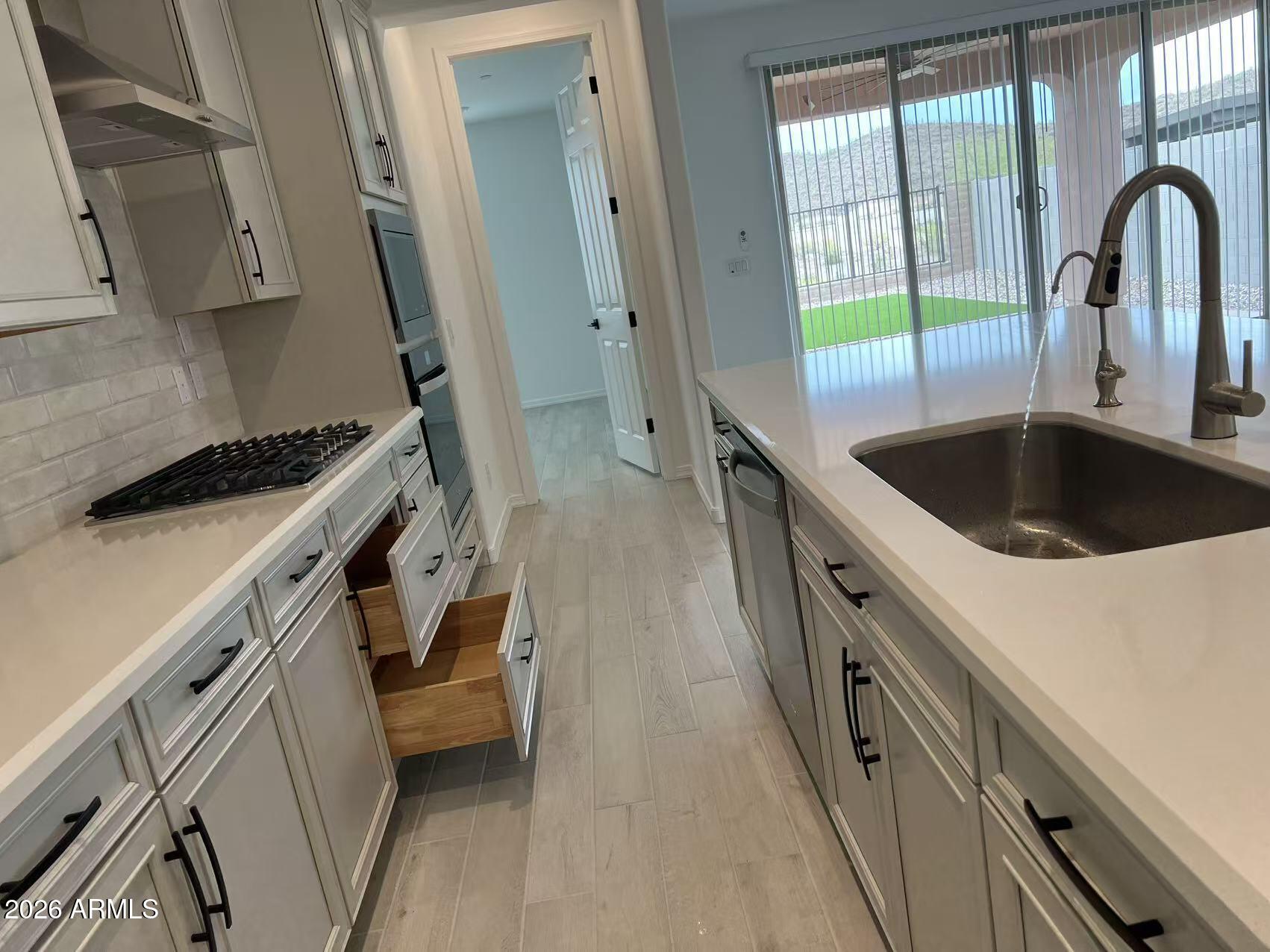 13362 West Eagle Feather Road Peoria, AZ 85383 - Photo 11 of 44 a kitchen with a sink a stove and cabinets