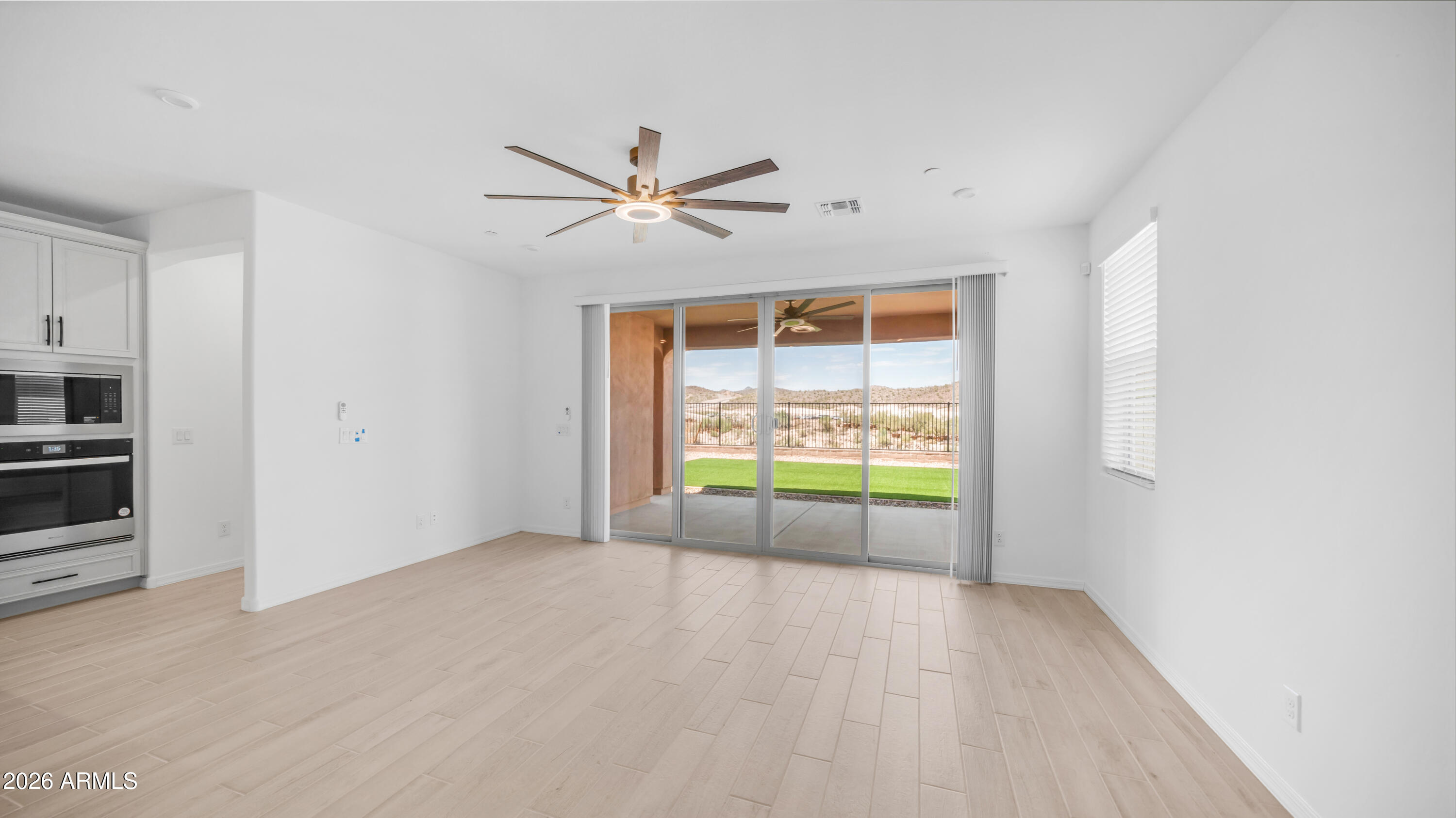 13362 West Eagle Feather Road Peoria, AZ 85383 - Photo 5 of 44 a view of an empty room with a window and kitchen view