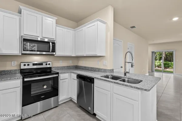 a kitchen with stainless steel appliances granite countertop a sink stove and microwave