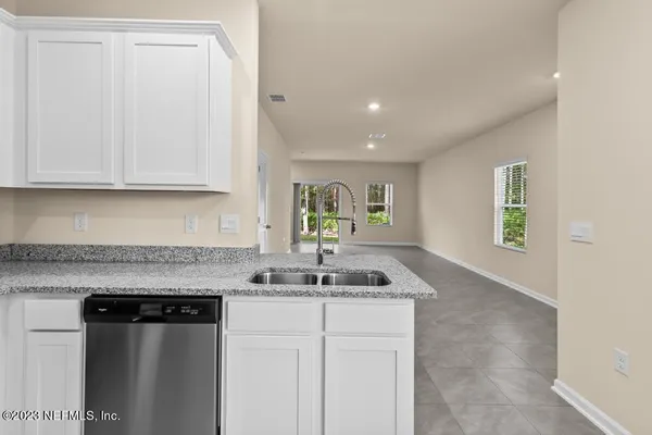 a kitchen with granite countertop a sink stainless steel appliances and cabinets