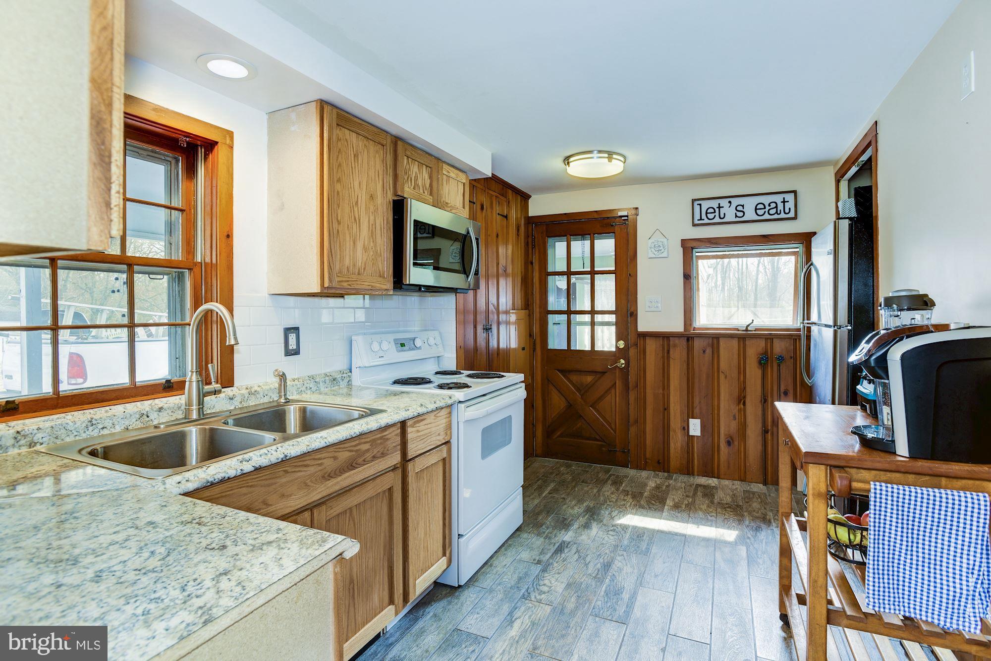4404 Church Road Mount Laurel, NJ 08054 - Photo 12 of 22 a kitchen with stainless steel appliances granite countertop a sink stove and wooden cabinets