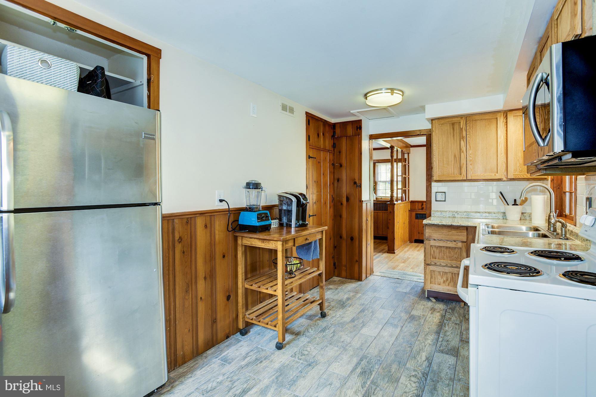 4404 Church Road Mount Laurel, NJ 08054 - Photo 14 of 22 a kitchen with stainless steel appliances granite countertop a refrigerator a stove a sink and a dining table with wooden floor