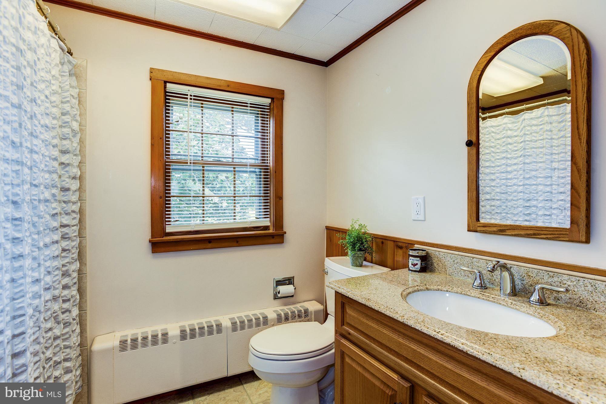 4404 Church Road Mount Laurel, NJ 08054 - Photo 16 of 22 a bathroom with a granite countertop toilet a sink a mirror and a window