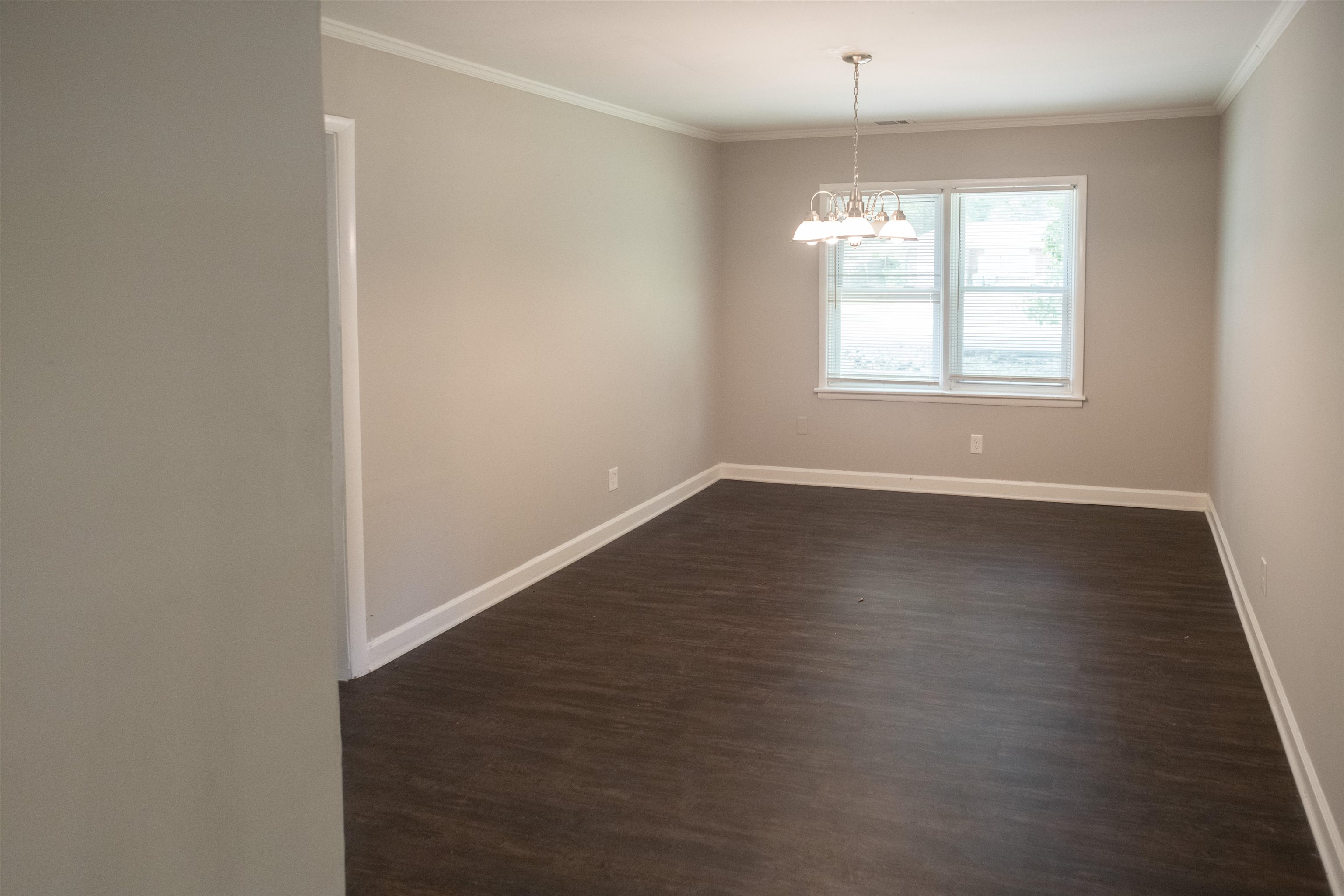 875 Enfield Road Memphis, TN 38116 - Photo 12 of 14 Spacious room featuring dark wood-finish flooring, neutral wall finishes, and crisp white trim throughout