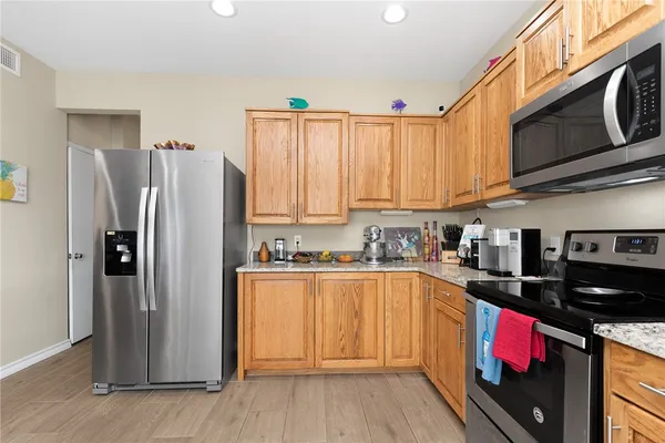 a kitchen with stainless steel appliances granite countertop a refrigerator and a stove top oven