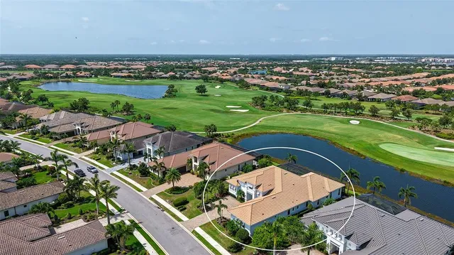 an aerial view of a residential houses with outdoor space and trees