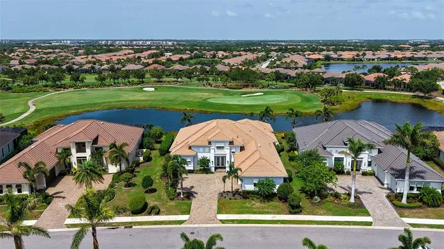 an aerial view of a house with a garden and lake view