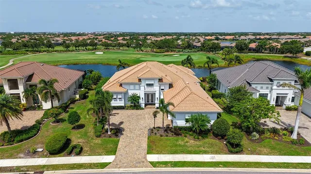 an aerial view of a house with garden space and lake view