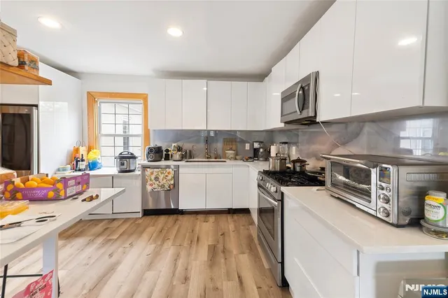 a kitchen that has a lot of cabinets a sink and appliances in it