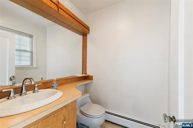 a bathroom with a granite countertop sink toilet and mirror