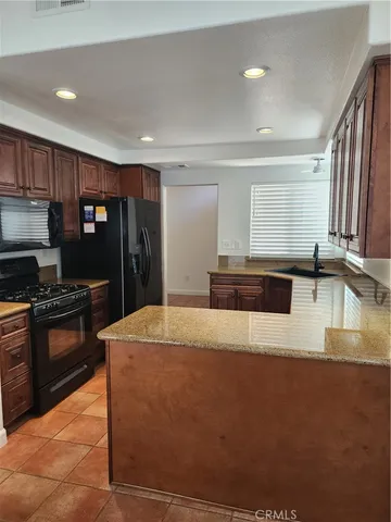 a kitchen with stainless steel appliances granite countertop a sink a stove a refrigerator a stove and a refrigerator with wooden floor