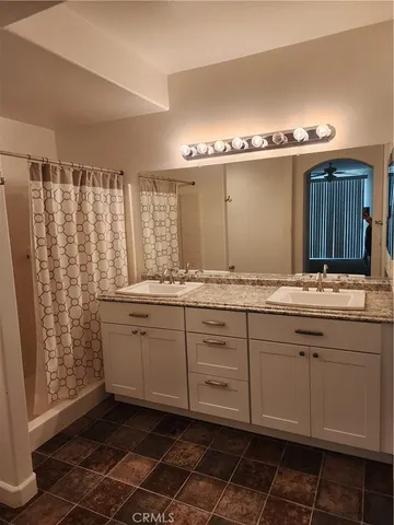 a bathroom with a double vanity sink and a mirror