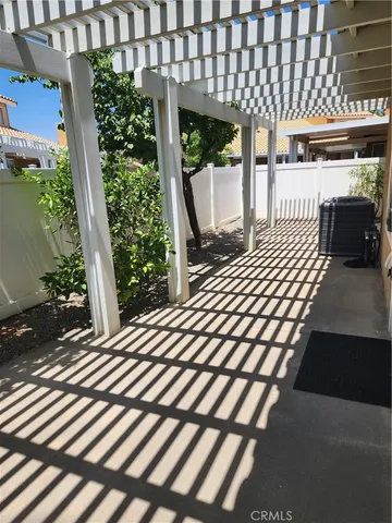 a roof deck with table and chairs and potted plants