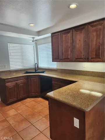 a kitchen with granite countertop a sink a stove and cabinets
