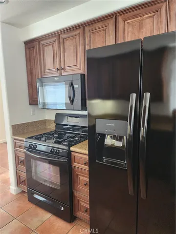 a kitchen with granite countertop a stove and a refrigerator
