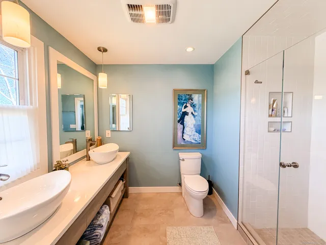a bathroom with a double vanity sink toilet and shower