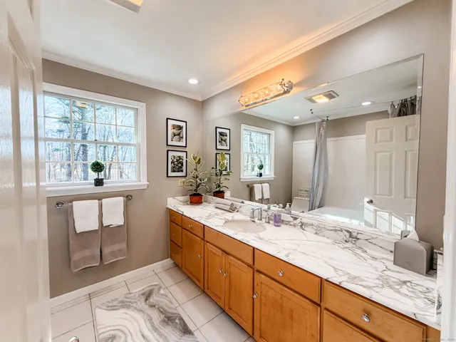 a bathroom with a sink double vanity granite and a large mirror