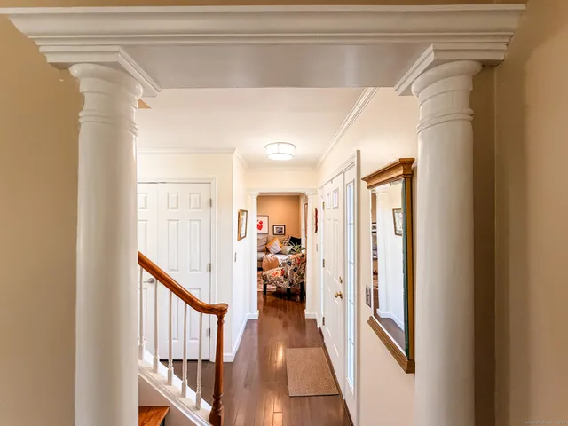 a view of a hallway with wooden floor and windows