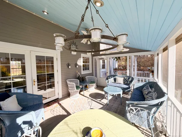 a living room with furniture ceiling fan and a large window