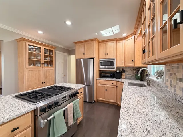 a kitchen with stainless steel appliances granite countertop a stove refrigerator sink and cabinets