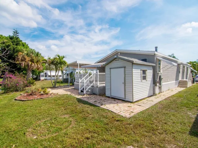 a view of a house with backyard and sitting area
