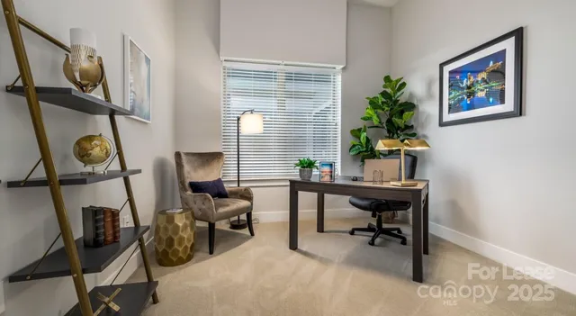 a view of a workspace with furniture and a window