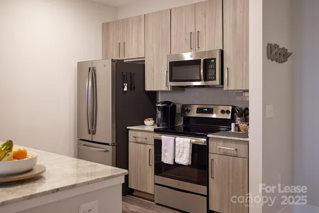 a kitchen with stainless steel appliances granite countertop a refrigerator stove and microwave