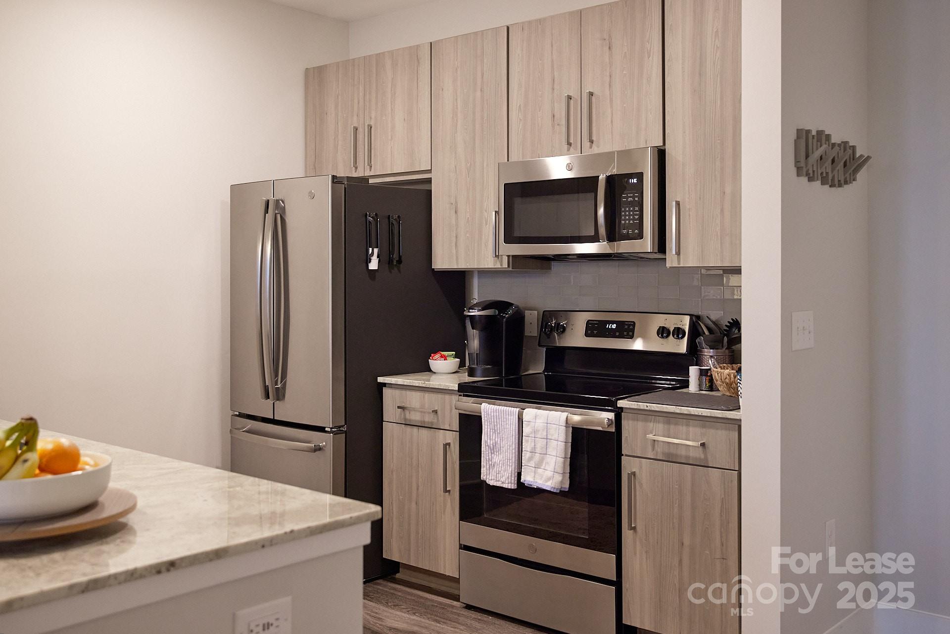 6805 Walnut Branch Lane, Unit 222 Charlotte, NC 28277 - Photo 16 of 22 a kitchen with stainless steel appliances granite countertop a refrigerator stove and microwave