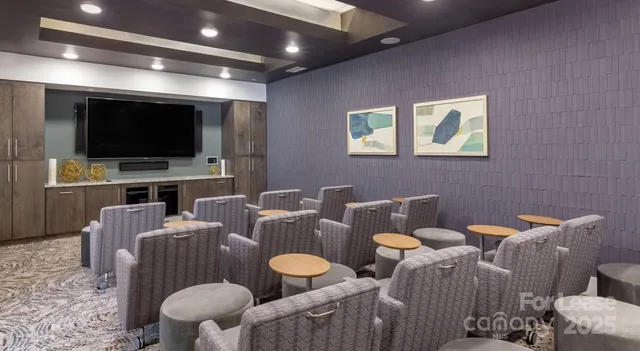 a living room with furniture a flat screen tv and kitchen view