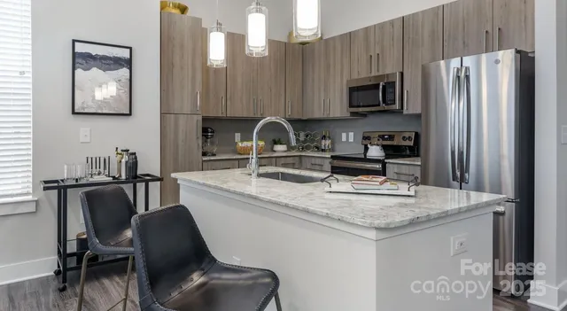a kitchen with granite countertop a sink cabinets and stainless steel appliances