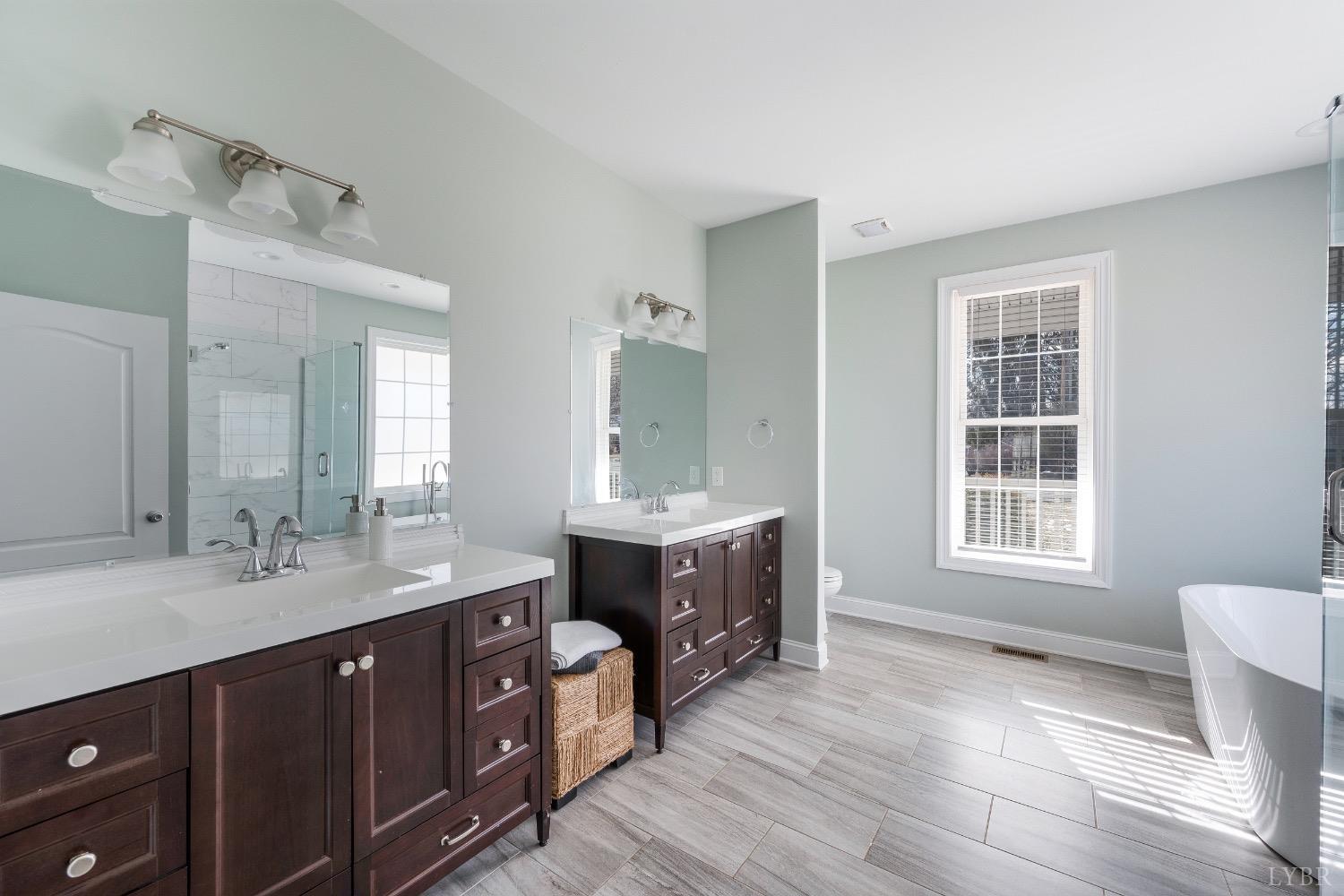 4802 Old Boonsboro Road Lynchburg, VA 24503 - Photo 33 of 57 a spacious bathroom with a double vanity sink large mirror and a bathtub