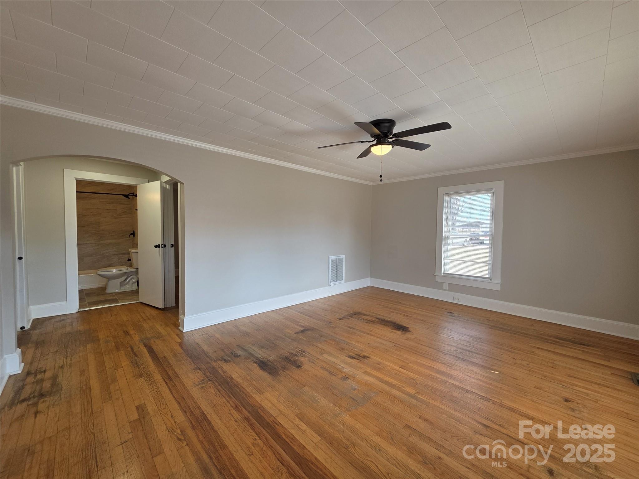 110 West 22nd Street Kannapolis, NC 28081 - Photo 3 of 15 an empty room with wooden floor and ceiling fan