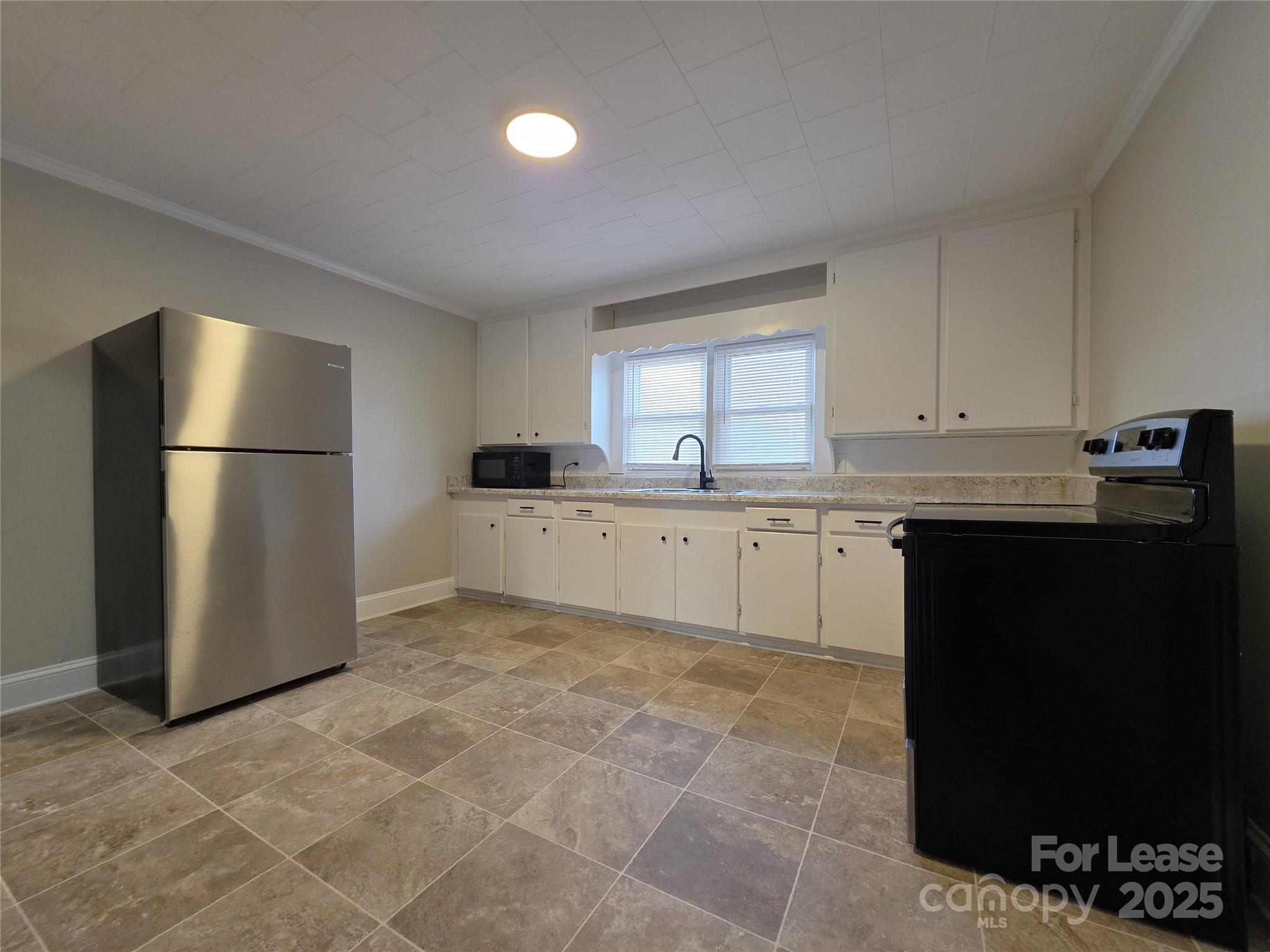 110 West 22nd Street Kannapolis, NC 28081 - Photo 4 of 15 a kitchen with a sink a refrigerator and cabinets
