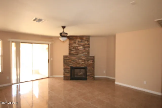 a view of an empty room with a fireplace and a window