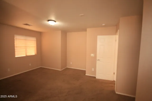 an empty room with a window and a ceiling fan
