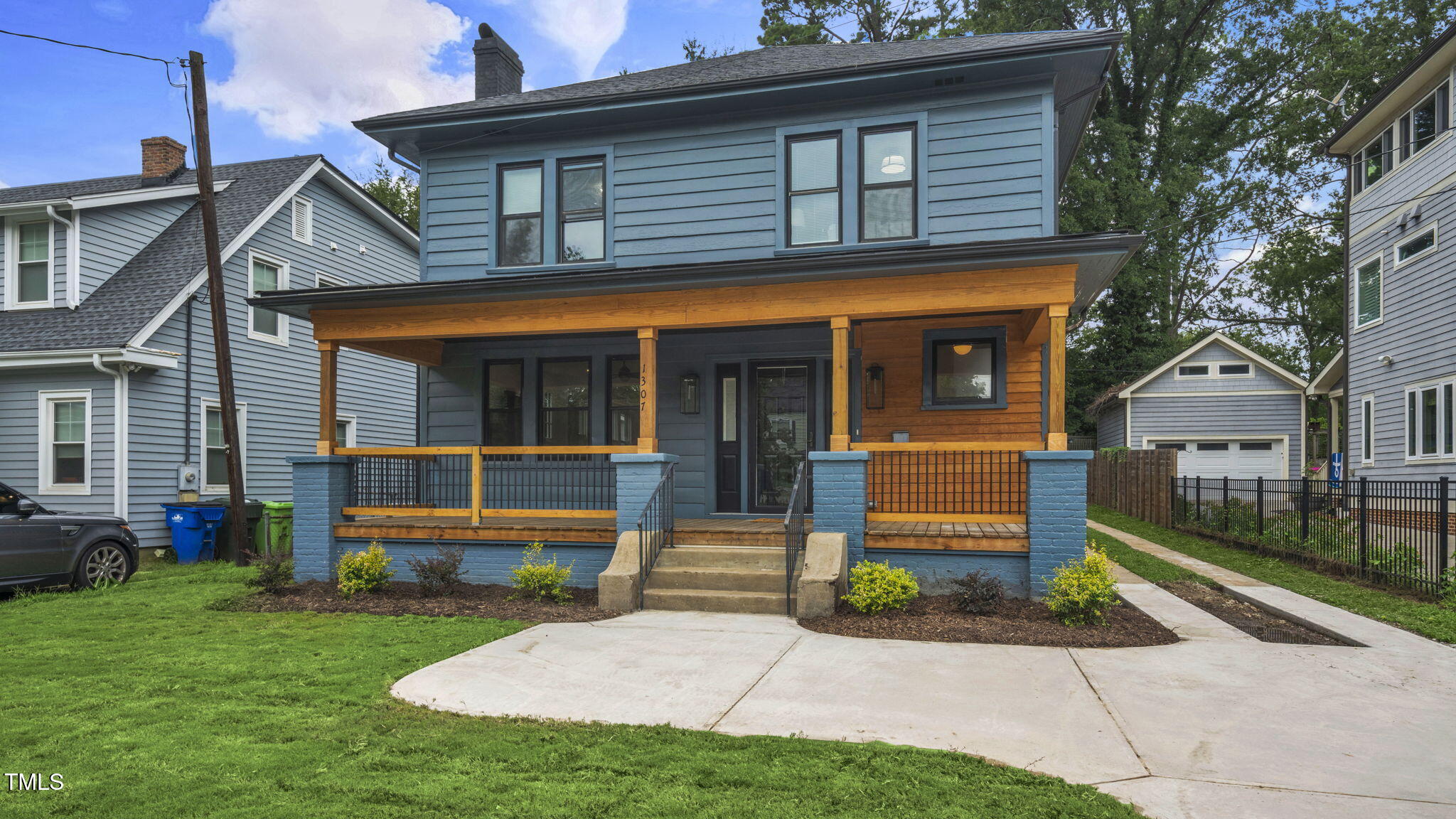 a front view of a house with a yard and potted plants