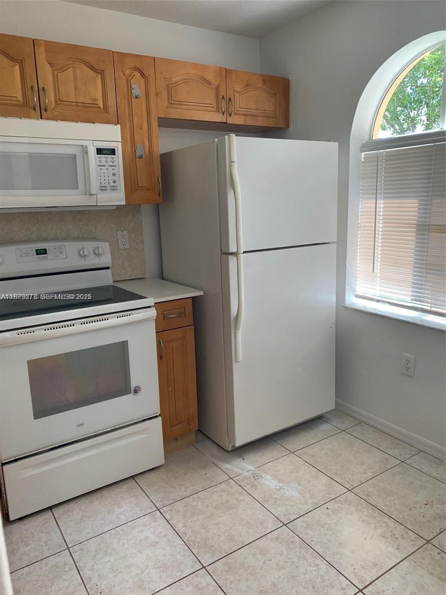 26232 Southwest 135th Place Homestead, FL 33032 - Photo 8 of 9 a kitchen with a stove and a refrigerator