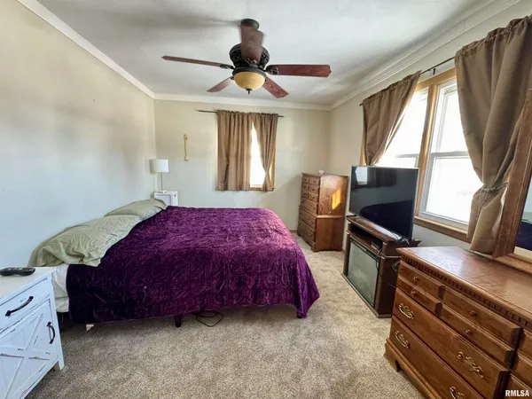 a spacious bedroom with a bed and a flat tv screen