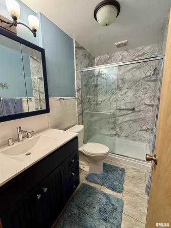 a bathroom with a toilet sink a mirror and shower