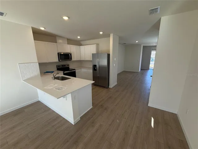 a view of a living room hardwood floor and a ceiling fan
