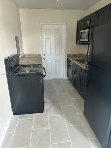 a kitchen with granite countertop a stove and a refrigerator